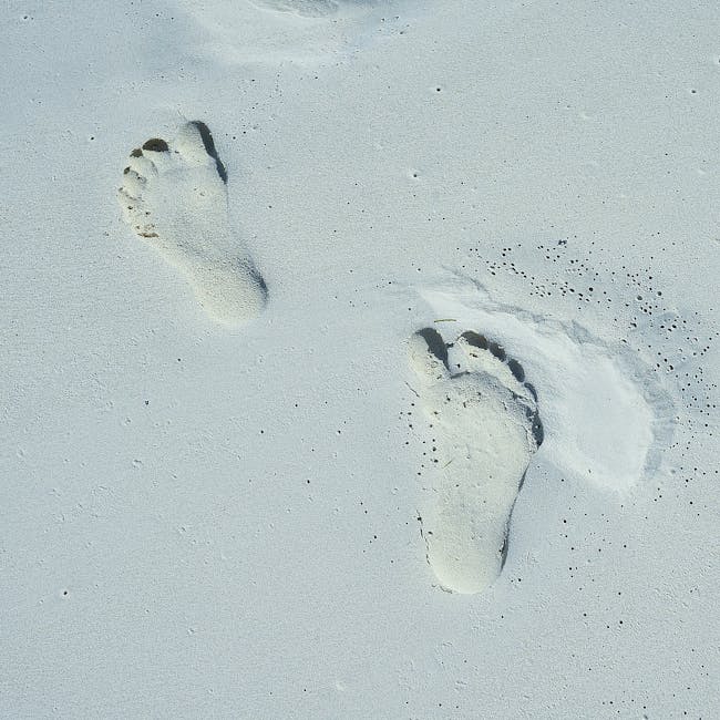 footprints in sand representing a gradual step by step journey